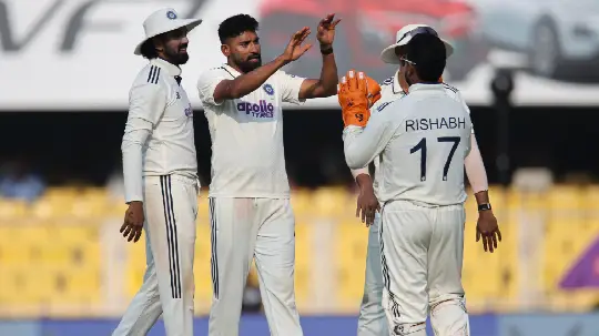 Indian cricket players celebrating a wicket on the field during a match